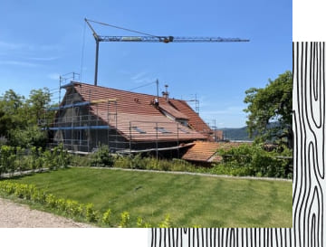 Baugerüste um ein Haus, an welchem eine Dachsanierung vorgenommen wird.